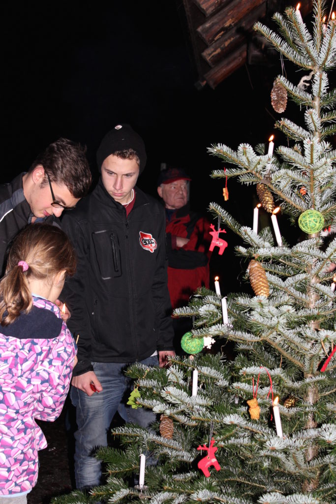 Die Kerzen des Christbaums werden angezündet